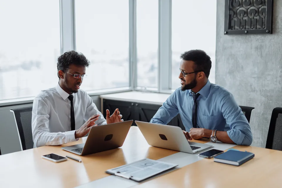 Deux professionnels examinent un projet sur leurs ordinateurs